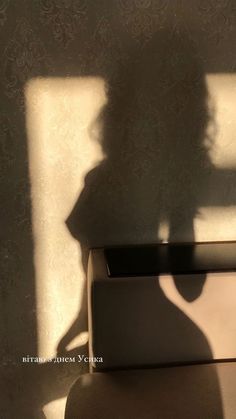 the shadow of a person standing next to a box