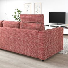 a red couch sitting on top of a hard wood floor