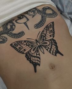 a woman's stomach with a butterfly tattoo on it