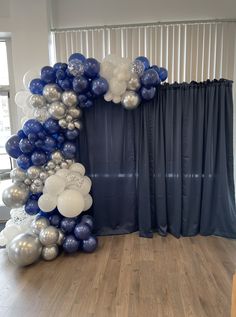 the balloon arch is decorated with blue and silver balloons