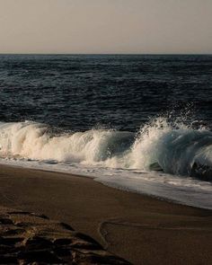 the waves are crashing on the beach near the shore