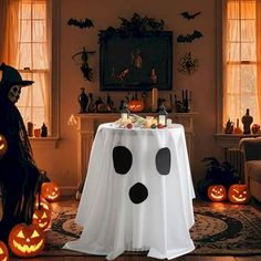 a table decorated for halloween with pumpkins and ghost faces on it in front of a fireplace