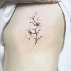 a woman's lower back tattoo with flowers on her stomach and the bottom part of her body