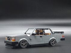 a toy car made out of legos on a gray surface with the top down