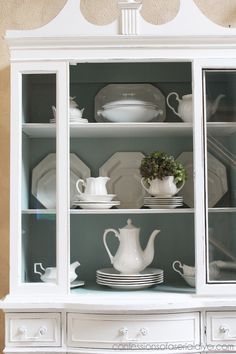 a white china cabinet with glass doors