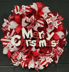 a red and white christmas wreath with the words merry christmas written in large letters on it