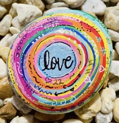 a rock with the word evil painted on it surrounded by rocks and pebbles in front of them