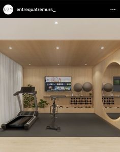 a gym with treadmills, exercise equipment and television on the wall in front of it