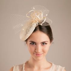 The millinery wedding hat in natural colour of sinamay is trimmed with a veiling bow for a touch of wedding tradition. With a voluminous bun or an elegant updo sitting glamorously under a this hat, your style will be striking and sophisticated. The bridal hat makes a civil ceremony feel like the special and unique moment.  Pictured in natural sinamay colour.  If you prefer this hat in more understated version, choose the colour matching your hair colour.  Available in various colour, please, see Beige Boater Hat For Wedding, Cream Straw Hat For Spring Wedding, Beige Straw Hat With Curved Brim For Wedding, Beige Curved Brim Straw Hat For Wedding, Elegant Cream Party Veil, Spring Wedding Cream Straw Hat, Beige Wide Brim Top Hat For Wedding, Sinamay Fascinator With Short Brim For Church, Church Fascinator With Short Brim In Sinamay