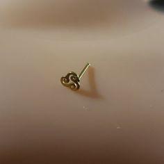 a pair of tiny gold earrings sitting on top of a table