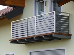 a balcony with shutters on the side of a building