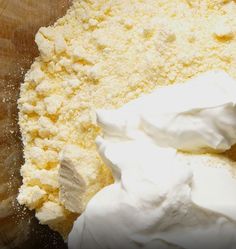 a bowl filled with whipped cream on top of a wooden table