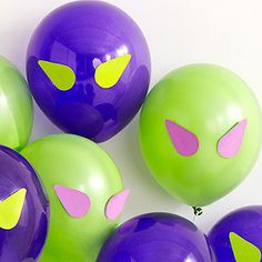 purple and green balloons with yellow eyes on them