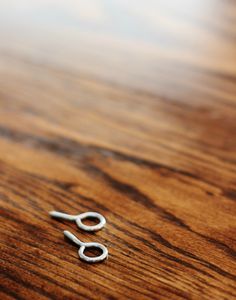 a pair of scissors sitting on top of a wooden table