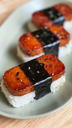 three pieces of sushi sit on a plate