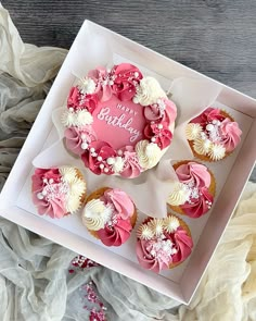 pink and white cupcakes in a box with the word happy birthday written on it