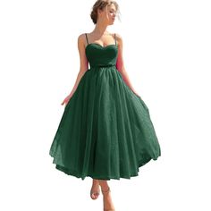 a woman in a green dress is standing on a white background with her hands behind her back