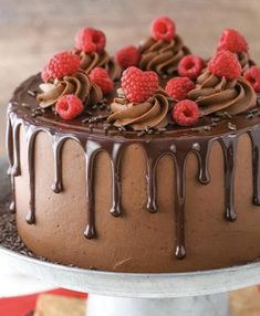 a chocolate cake with raspberries and chocolate icing