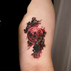 a red and black tattoo on the arm