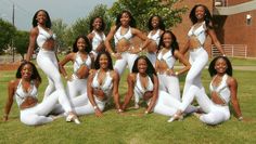 a group of women in white outfits posing for a photo