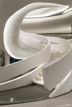 the interior of a modern building with curved stairs