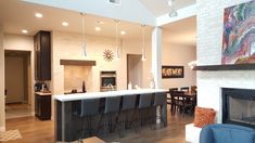 a living room filled with furniture and a fire place in front of a kitchen counter