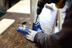 a person using a drill to cut wood