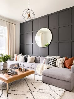 a living room filled with furniture and a large mirror on the wall above it's headboard