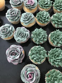 cupcakes decorated with green and pink frosting are on a table next to other cupcakes