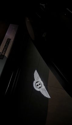 an owl logo is shown on the side of a building at night with its wings spread out