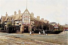 an old photo of people walking in front of a building with many windows and chimneys