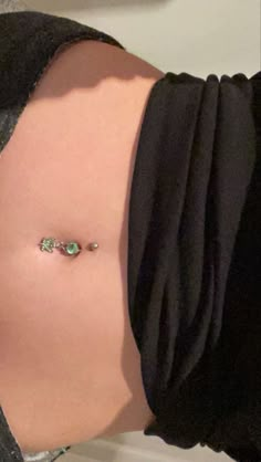 a woman's stomach with a piercing on it