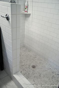 a white tiled bathroom with a shower stall