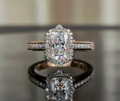 an engagement ring with a cushion cut diamond surrounded by pave and round brilliant diamonds