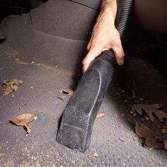 a man is using a vacuum to clean his car's floor and upholster