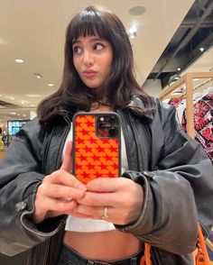 a woman holding up her cell phone in front of the camera and making a funny face