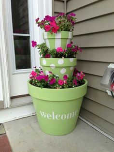 three flower pots are stacked on top of each other with the word welcome painted on them