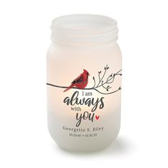 a candle with a red bird on it that says, i am always with you