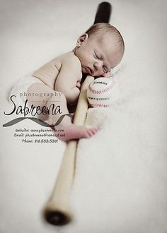 a baby sleeping on top of a baseball bat