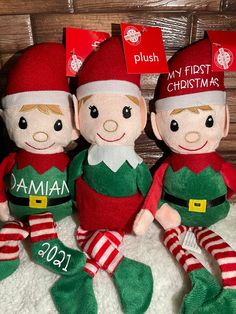 three plush christmas elfs sitting next to each other