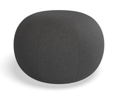 a grey round ottoman sitting on top of a white floor