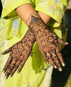 a woman's hands with hennap on her arm and hand, showing the intricate