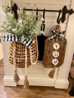 two baskets with flowers are hanging from hooks on the wall in front of a door