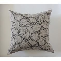 a black and white pillow sitting on top of a wall