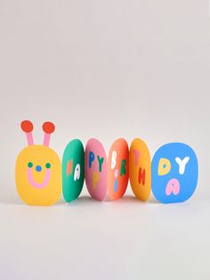 three colorful eggs with the words happy birthday written on them in different colors and shapes