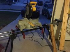 a machine that is sitting on top of a tripod in the garage next to a building