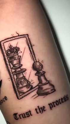 a tattoo that reads trust the process with chess pieces in front of a mirror and an arrow