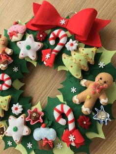 a wreath made out of felt with christmas decorations on it and candy canes in the middle