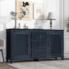 a living room area with a chair, sideboard and pictures hanging on the wall