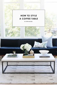 a living room with black couches and white coffee table